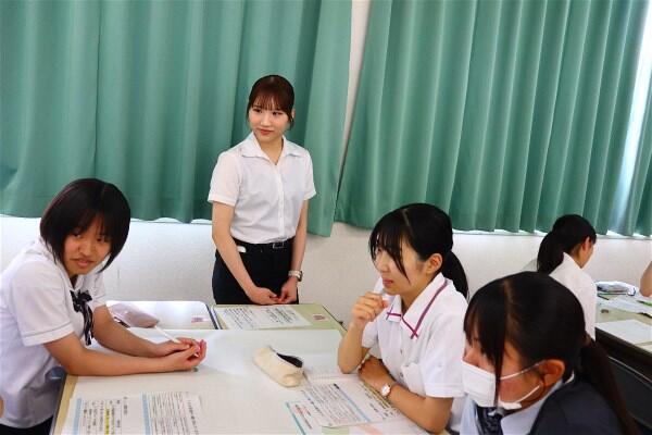 グループワークで高校生にアドバイスをする学生