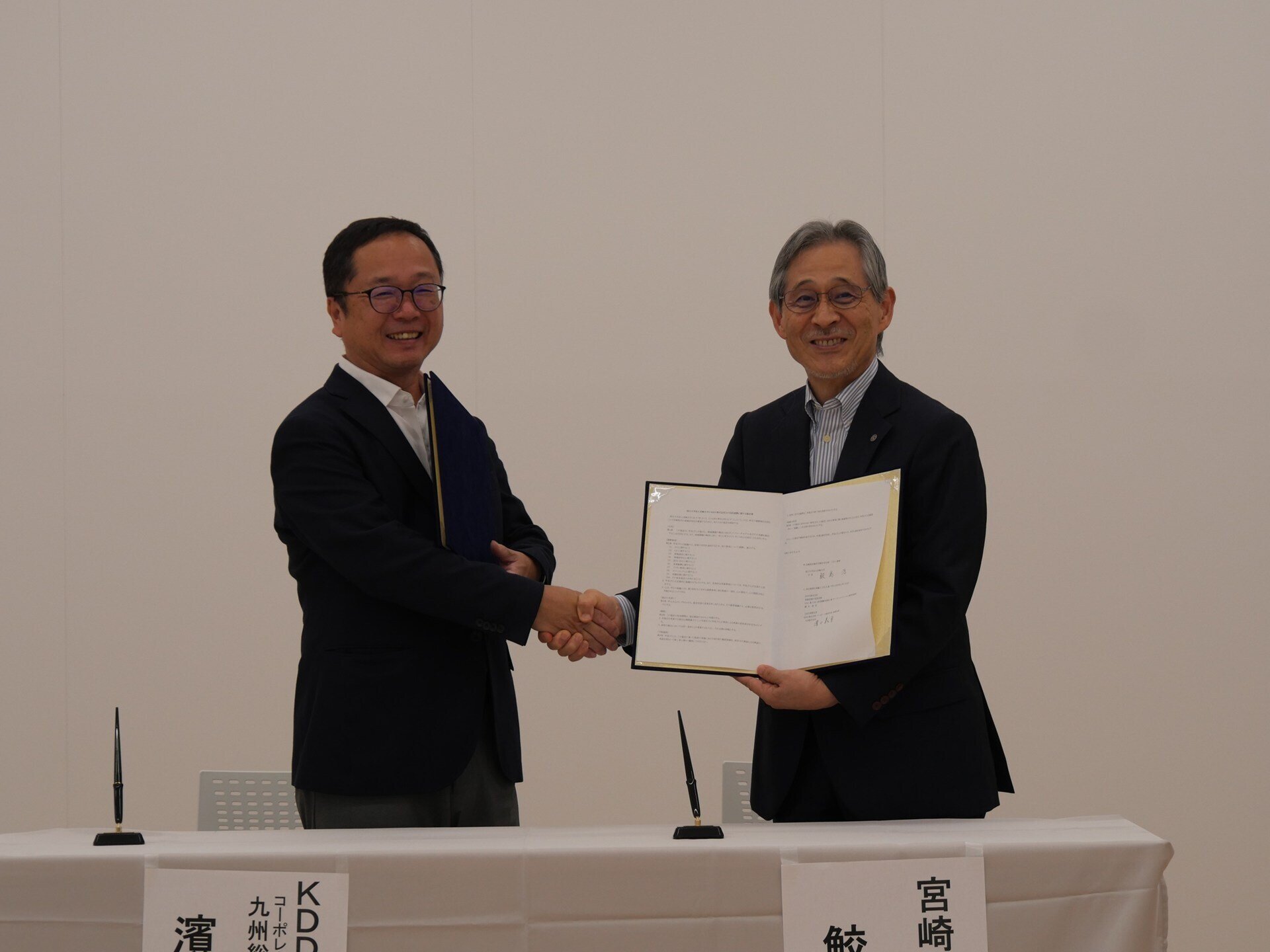 定締結後握手をする鮫島学長と濱口KDDI九州総支社長